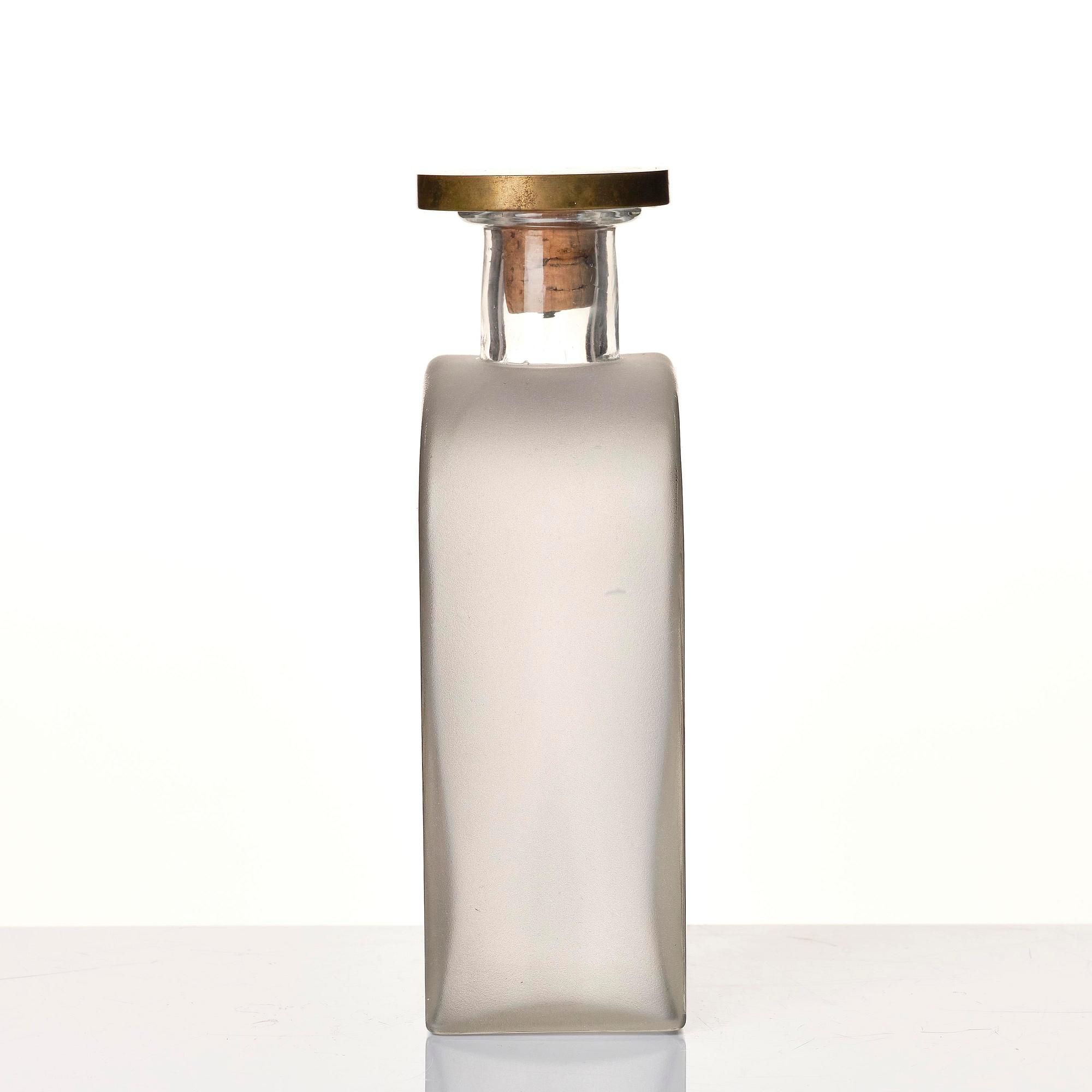 Firma Svenskt Tenn, a glass bottle model A 1608, with a pewter and brass stopper by Björn Trägårdh, Stockholm, 1930s.