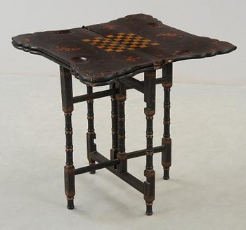 A black and gold laquered games table, 18-19th century.