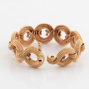 An 18K gold bracelet set with round brilliant-cut diamonds and rubies.