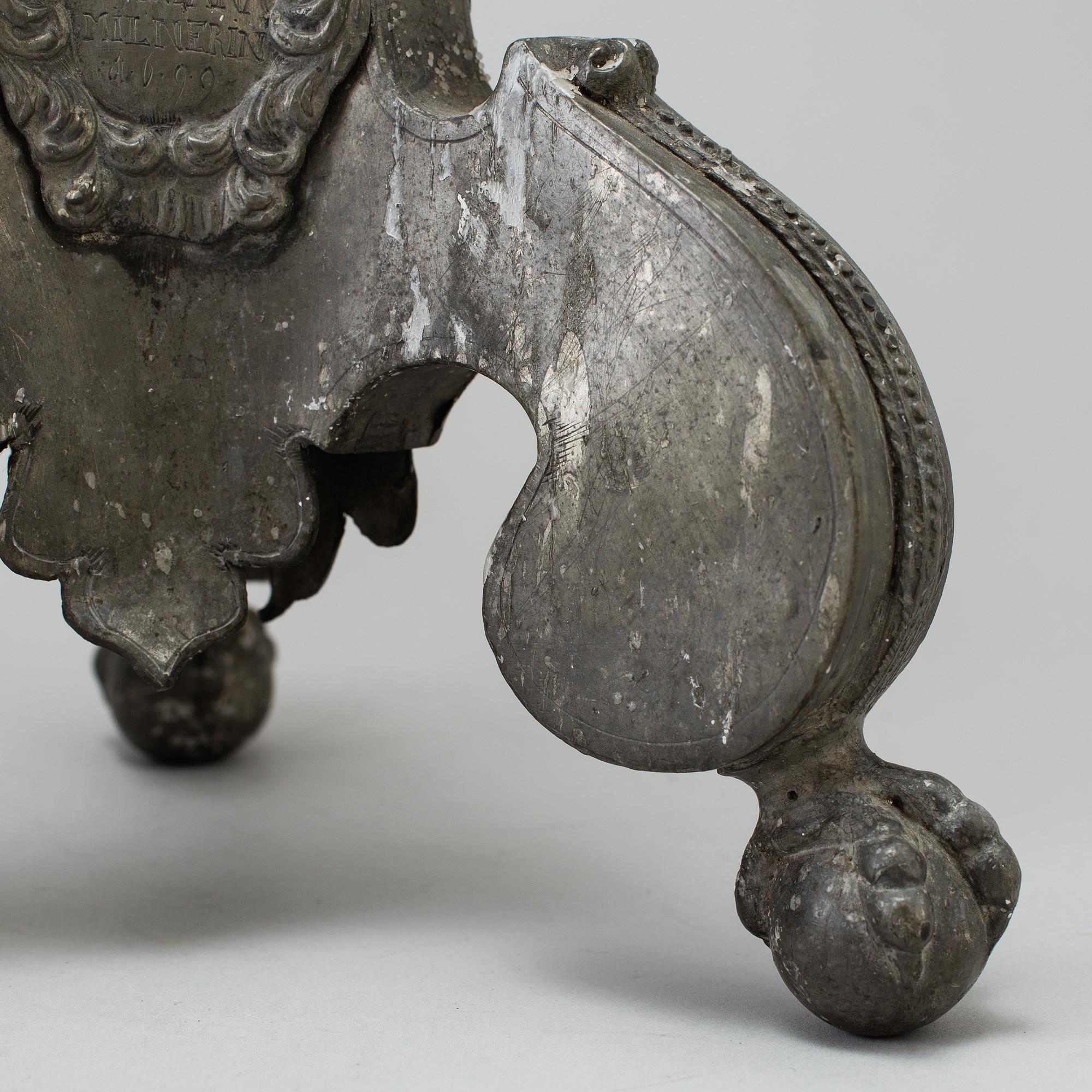 A pair of baroque pewter candlesticks, engraved date 1699.