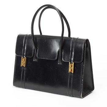 A 1950s black leather handbag by Hermès.