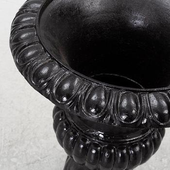 A pair of cast iron garden urns, 20th century.