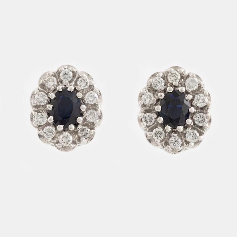 A pair of 18K white gold earrings set with sapphires and round brilliant-cut diamonds.