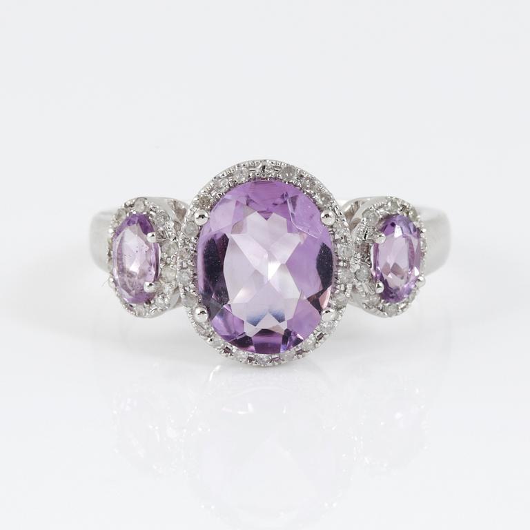 RING, 14k vitguld med tre ovalslipad ametist tot ca 2,03 ct omgivs av små åttkantslipade diamanter. Vikt 4,08 g.