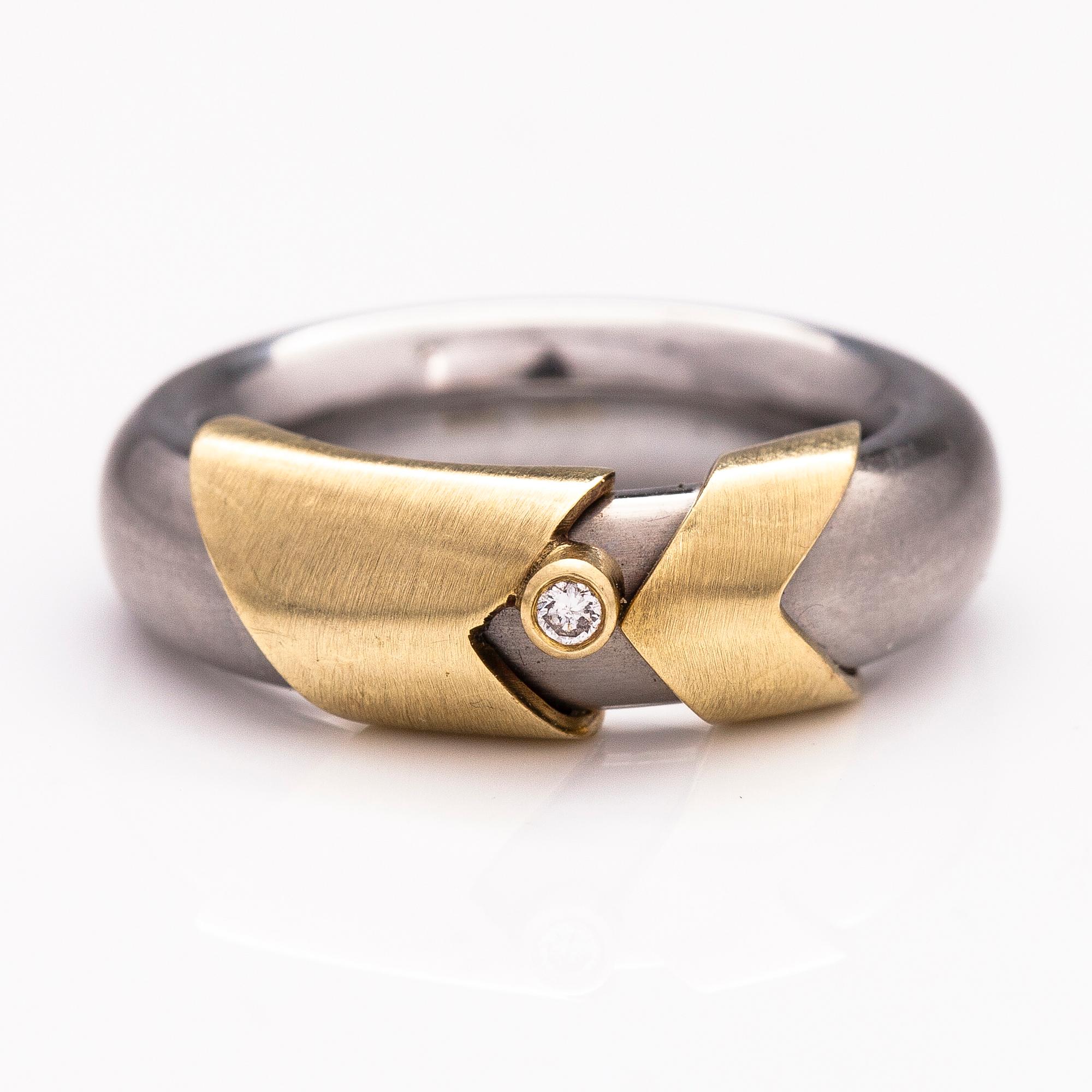 A steel and gold ring with a diamond ca. 0.015 ct.