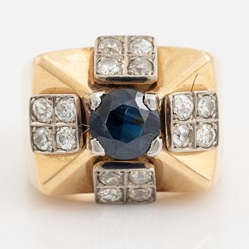 An 18K gold ring set with a faceted sapphire and diamonds.