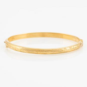 An 18K gold bangle.