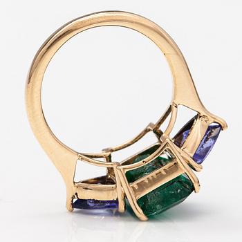 A 14K gold ring with tanzanites and a ca 5.80 ct emerald.