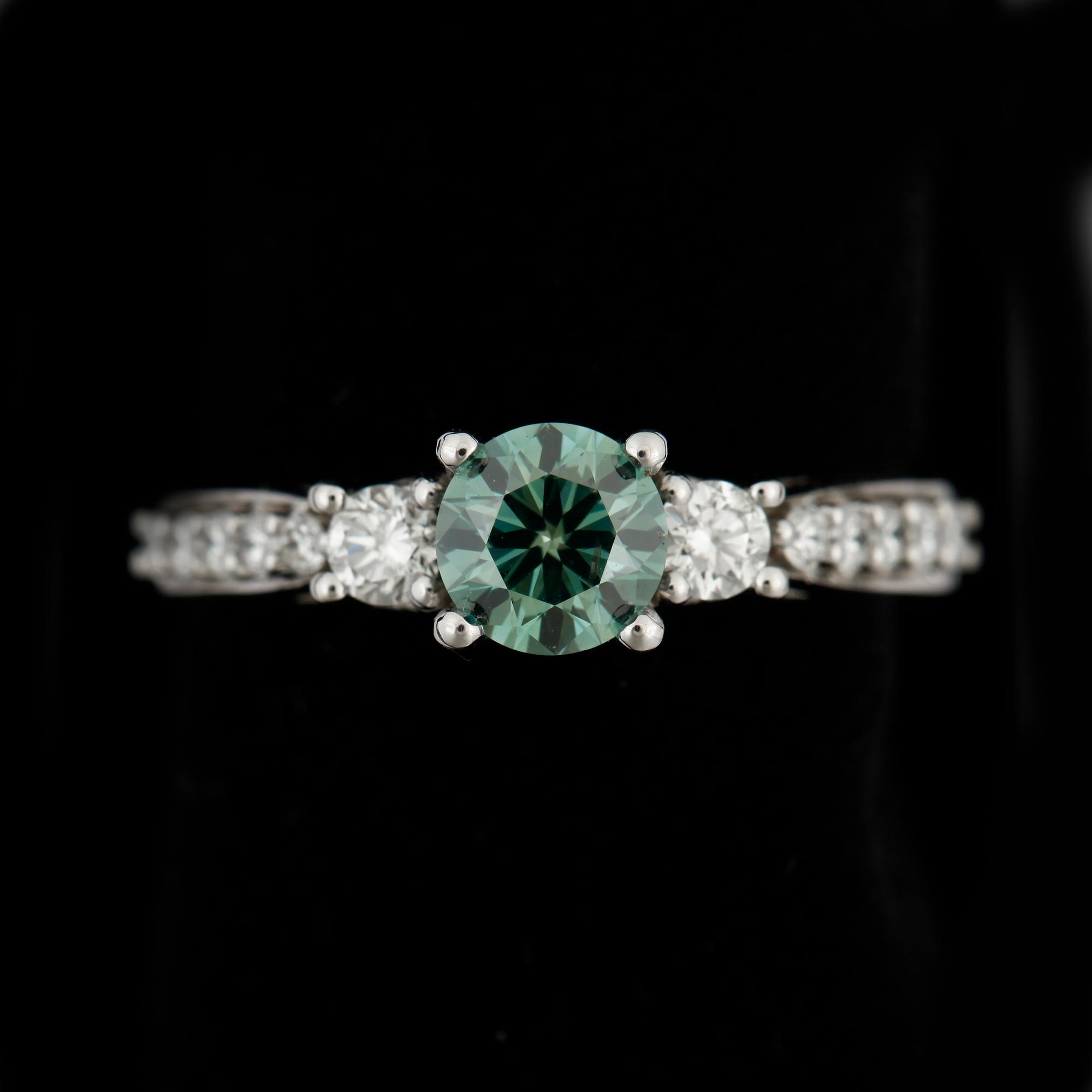 RING, 18k vitguld med mittsten grön briljantslipad diamant ca0,73ct o briljantslipade diamanter tot ca0,40ct. Vikt 4,7g.