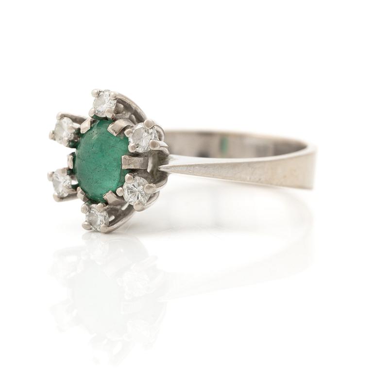 Ring 18K vitguld med en cabochonslipad smaragd och runda briljantslipade diamanter, Stockholm 1976.