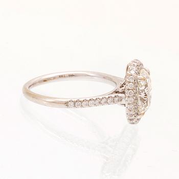 An 18K white gold ring by James Allen, set with an oval brilliant cut diamond in a halo of round brilliant cut diamonds.