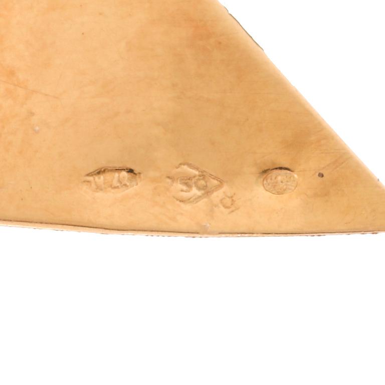 an 18K gold broosch with rubies, possibly synthetic.