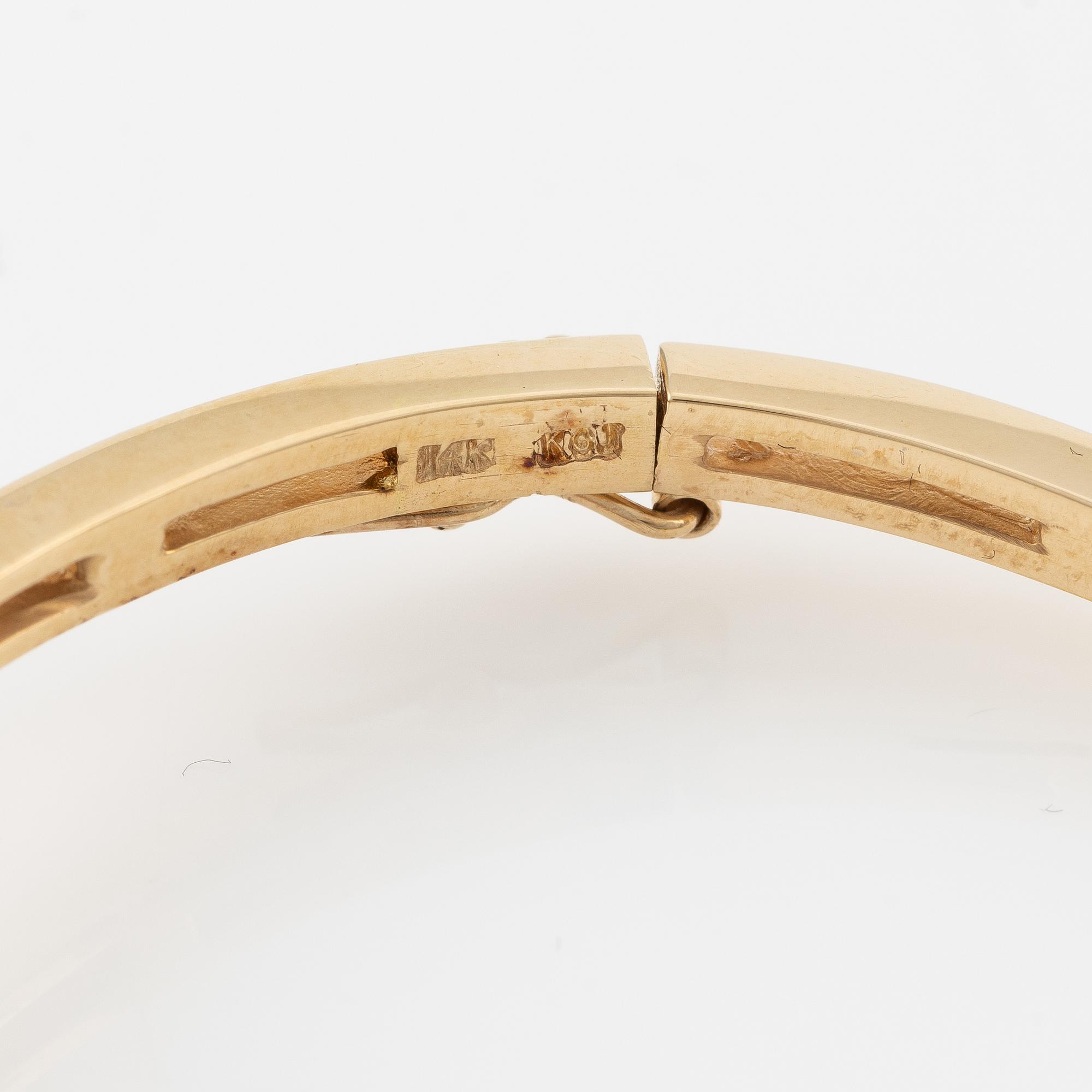 A bangle in 14K gold with round brilliant-cut diamonds.