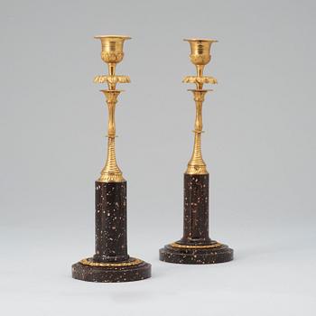 Two matched late Gustavian early 19th century porphyry and gilt bronze candlesticks.