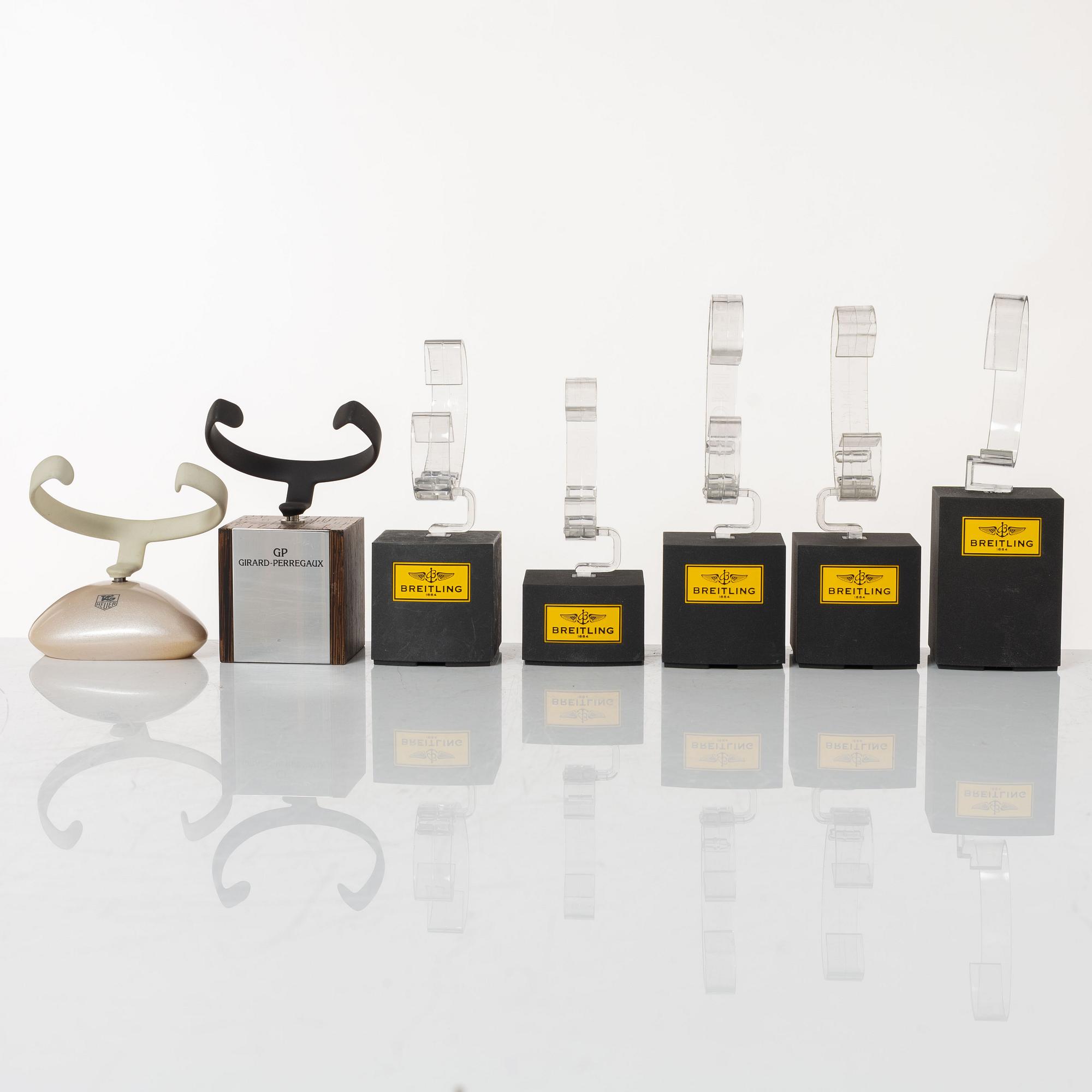 Clock stands, 7 pcs, Breitling, TAG Heuer and Girard-Perregaux.