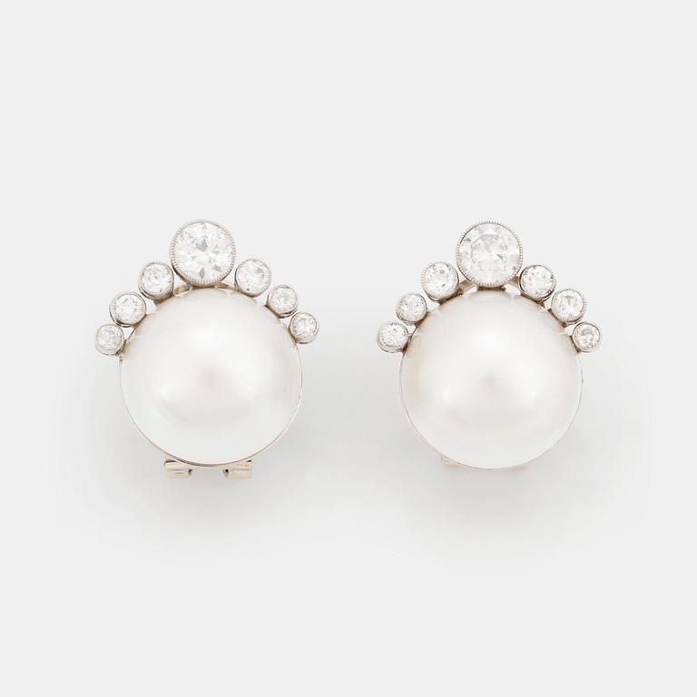 A pair of 18K white gold earrings set with mabe pearls and round brilliant-cut diamonds.