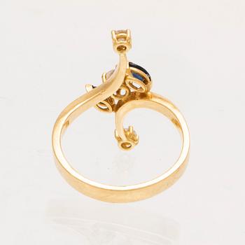 An 18K gold ring with marquise cut sapphires and round brilliant cut diamonds.