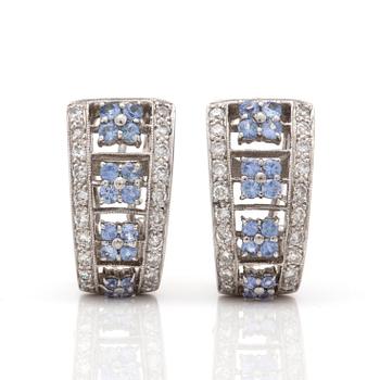 A pair of earrings with round, mixed-cut diamonds and probably sapphires.