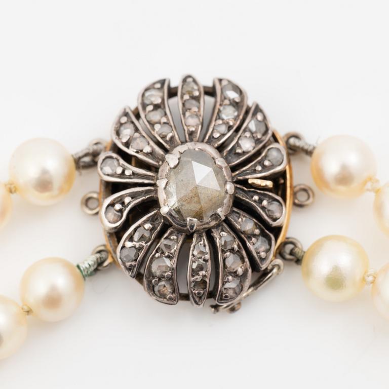 Two-row cultured pearl necklace with a silver and 18K gold clasp set with rose-cut diamonds.