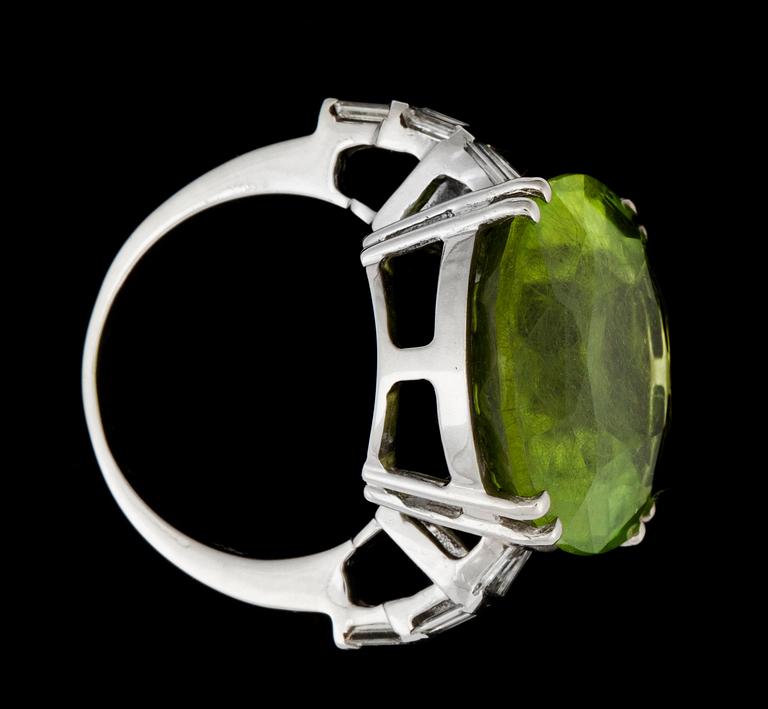 A 29.50 cts peridote and diamond ring. Total carat weight of diamonds 0.60 ct.