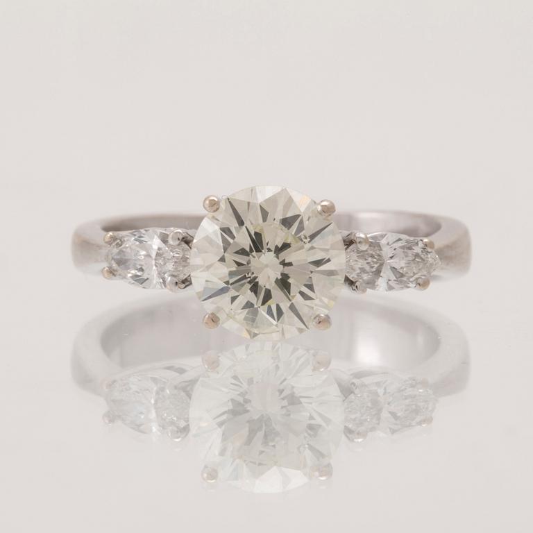 An 18K white gold ring set with one round brilliant-cut diamond and two marquise-cut diamonds.