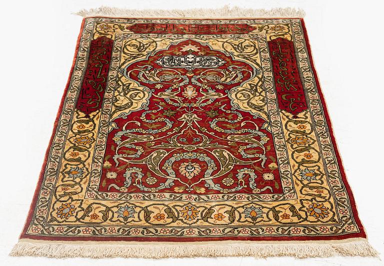 A silk and metal Hereke rug, c. 86 x 52 cm.