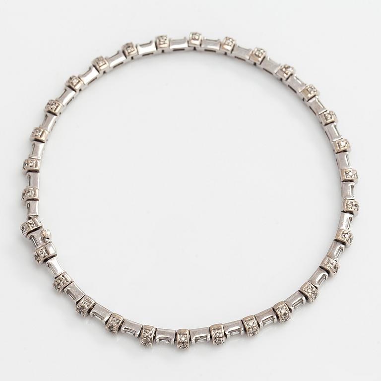 An 18K white gold bracelet set with baguette and brilliant-cut diamonds.