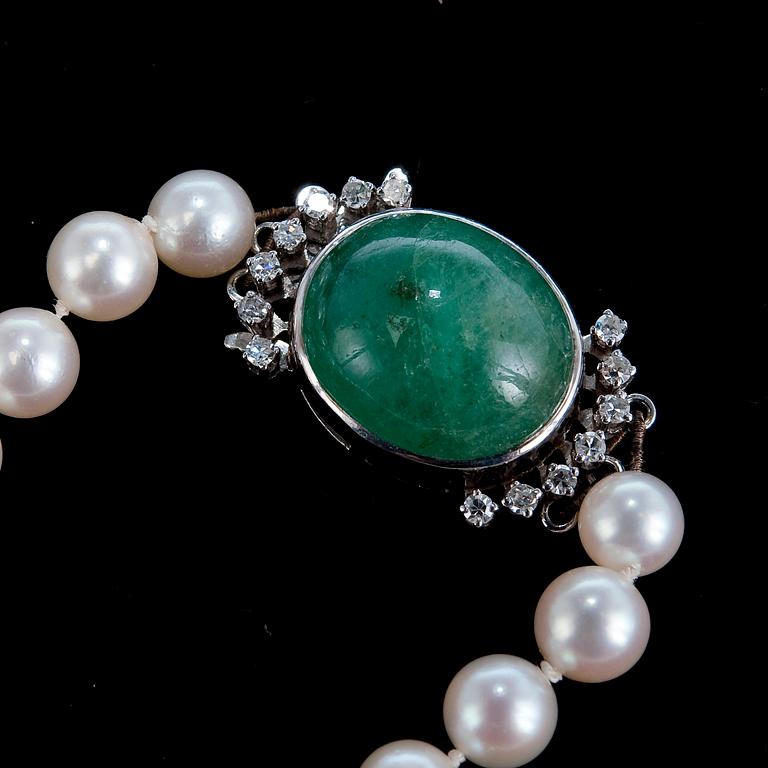 A NECKLACE, cultivated pearls Ø 6 mm, clasp with a cabochon cut emerald c. 13.5 ct, 16 x 14 mm.