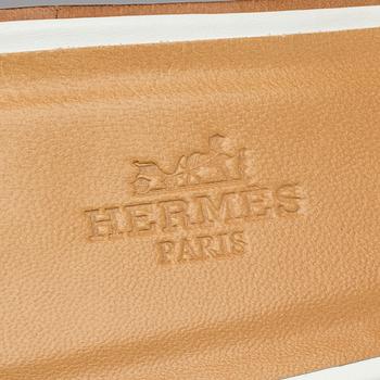 A pair of white leather shoes by Hermès.