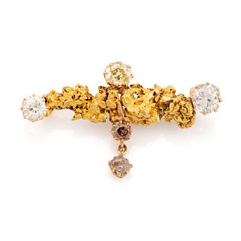 A gold brooch set with old-cut diamonds and an uncut diamond.