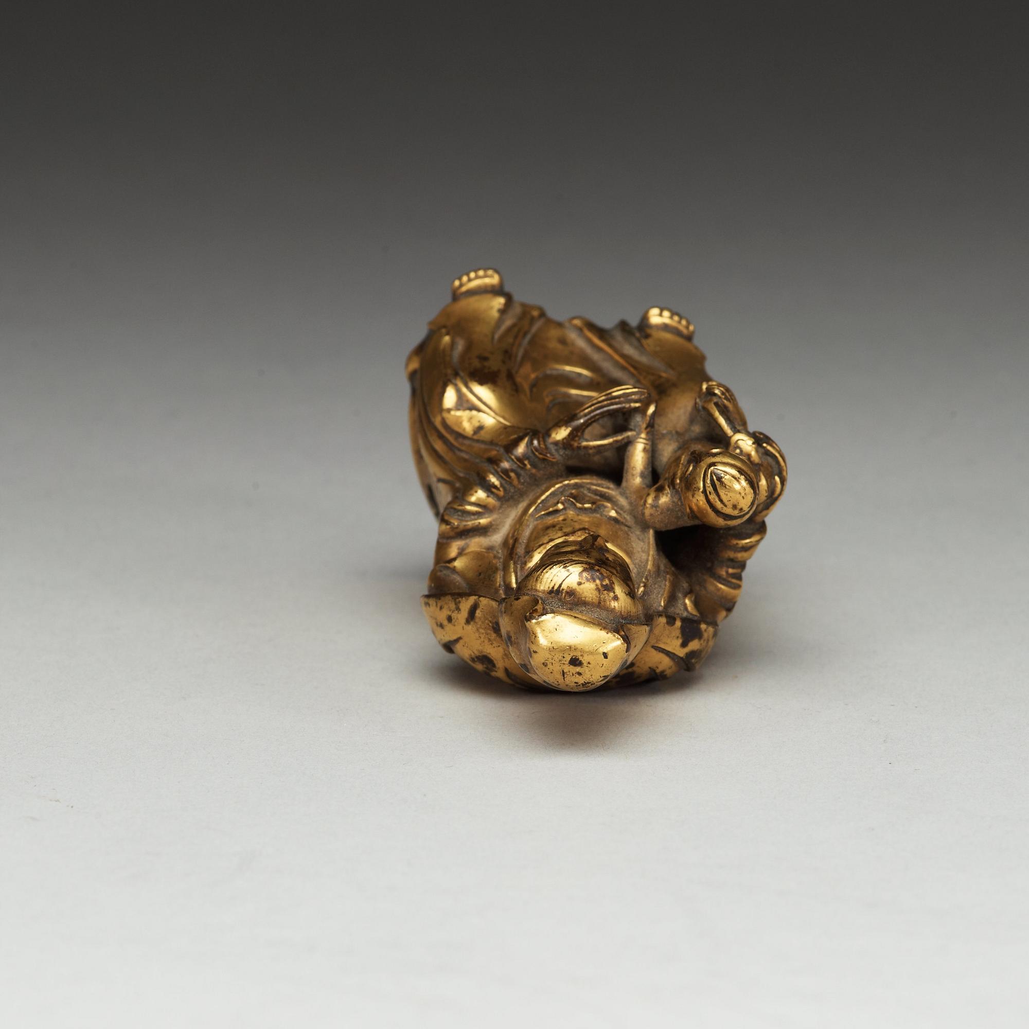 A seated gilt bronze figure of Guanyin with a small boy, Qing dynasty, 18th Century.