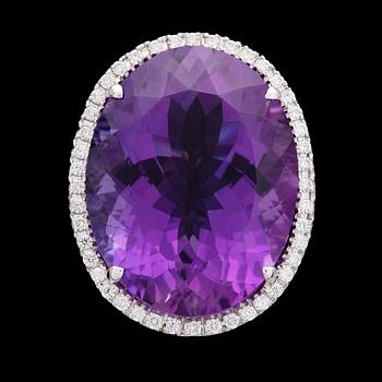 947. An oval amethyst, 22.49 cts and brilliant cut diamond ring, tot. 0.69 cts.