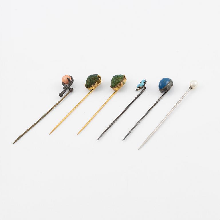 Six brooch pins in various designs and materials.