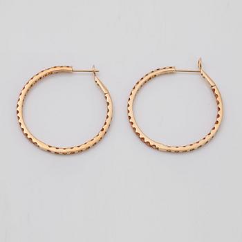 A pair of orange-yellow sapphire hoop earrings.