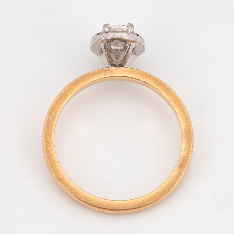 An 18k gold ring set with an oval brilliant-cut diamond.