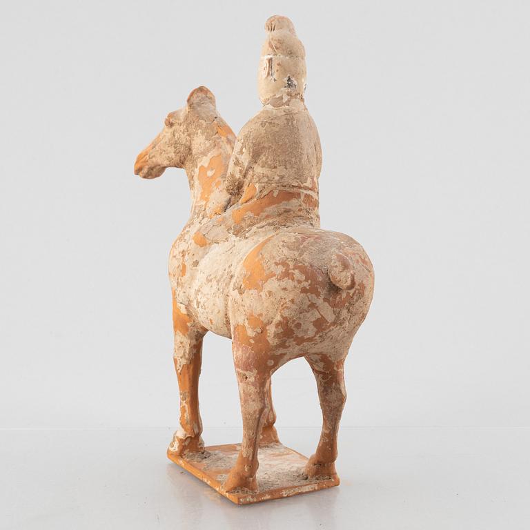 A painted pottery figure of an equestrian standard-bearer, Tang dynasty (618-907 AD.).
