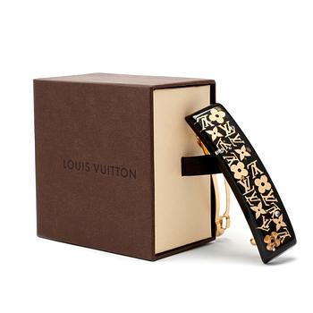 467. LOUIS VUITTON, a black acrylic and gold hair clip.