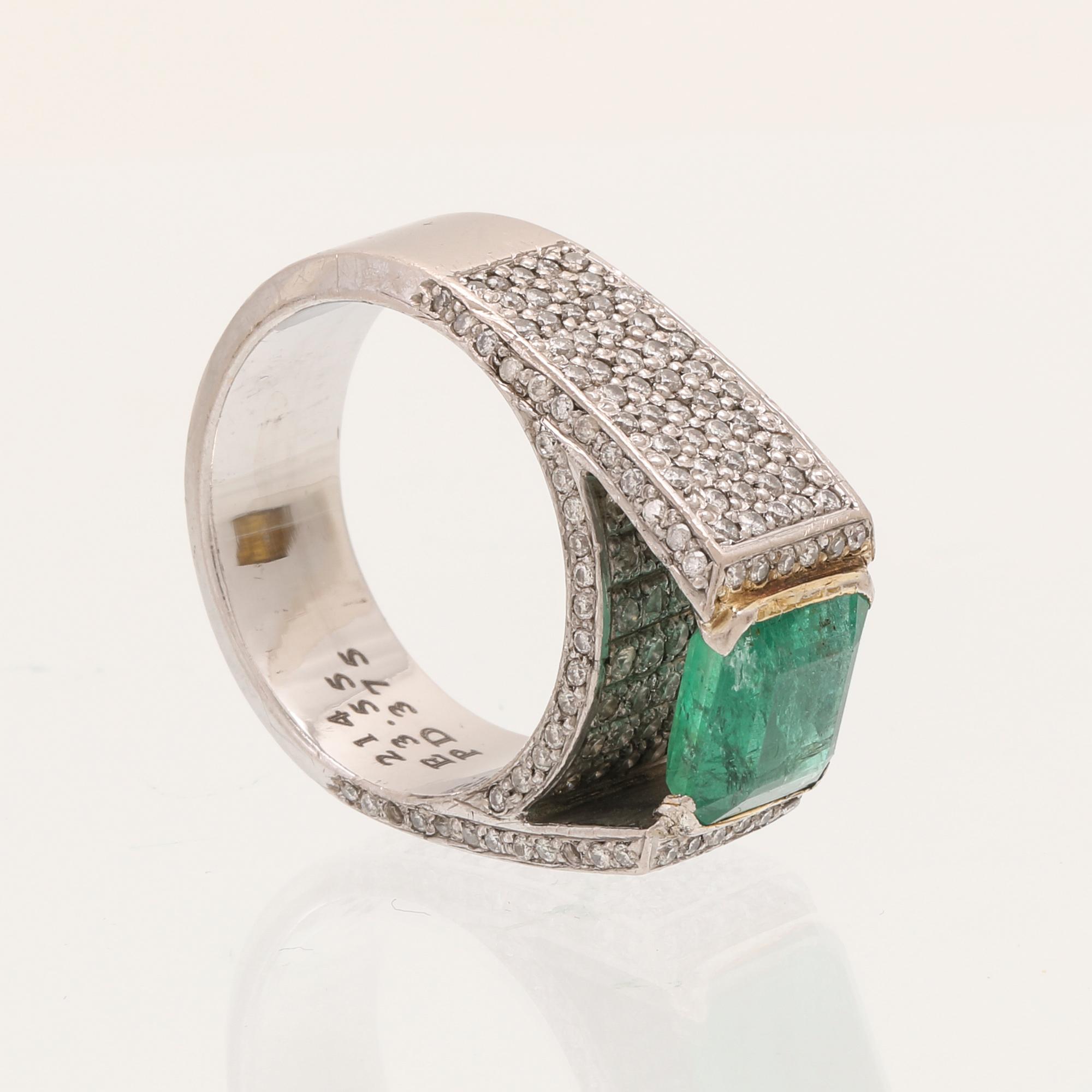 A 9K white gold ring with an emerald and brilliant cut diamonds.