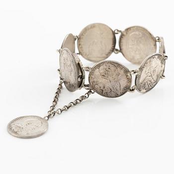 Two bracelets, a brooch, and a pendant with coins.