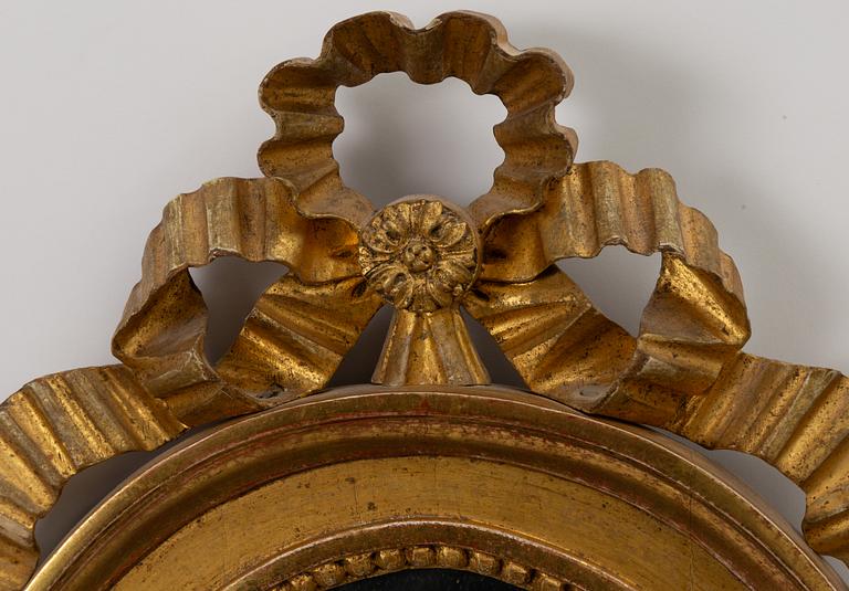 A pair of late Gustavian one-branch giltwood girandole mirrors, Stockholm, circa 1800.