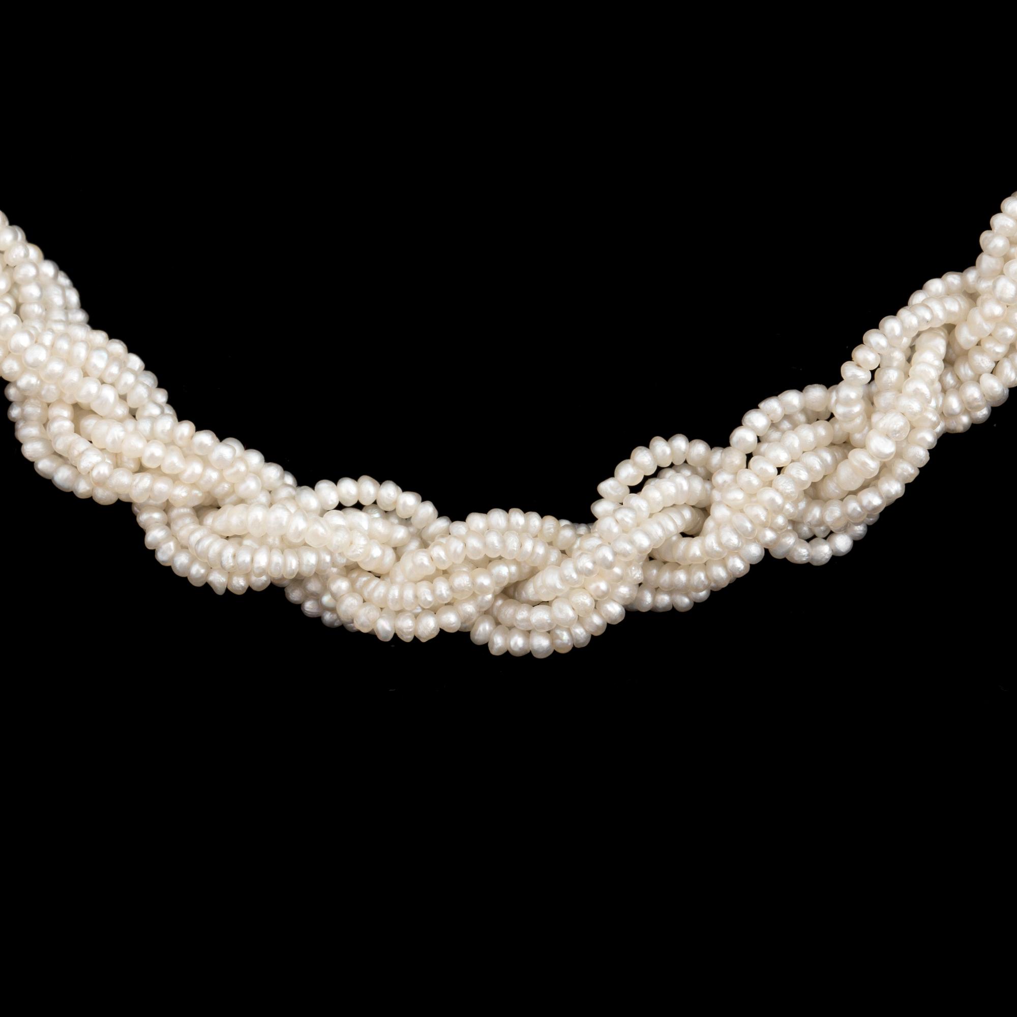 A necklace of cultured pearls and seed pearls with a silver clasp decorated with probably synthetic rubies.