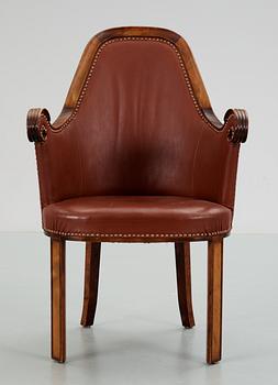 A Swedish easy chair in stained birch, upholstered in artificial leather, by NK, Nordiska Kompaniet, 1910's-20's.