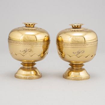 A set of eight polished brass pomme granate shaped jars with covers on stands, Marked Siam, Amfar Co.
