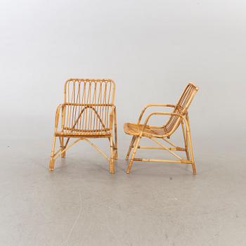 A pair of ratten mid 20th century armchairs and a lounge table.