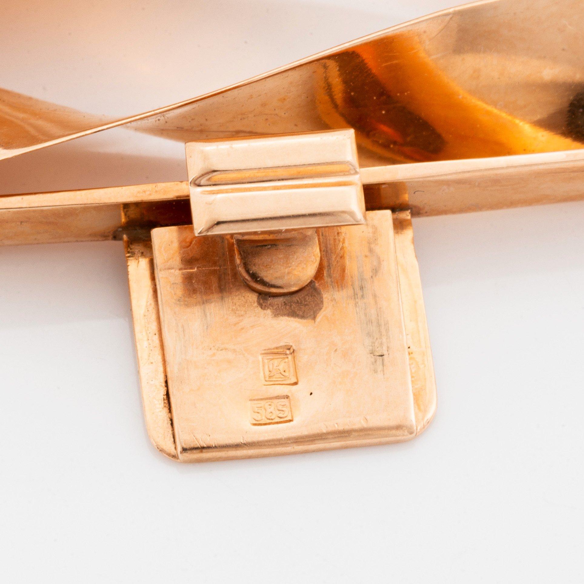 A 14K gold bracelet and a brooch.