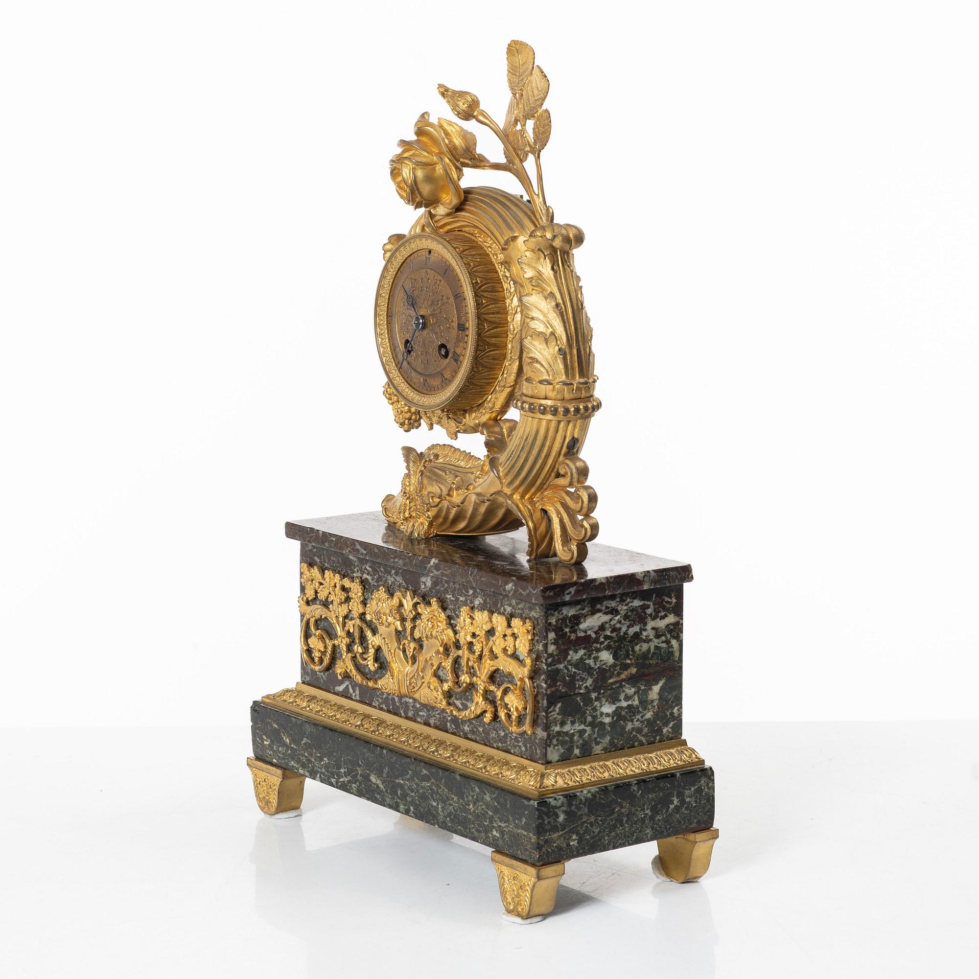 A presumably French Empire-style gilt bronze and marble mantel clock, later part 19th century.