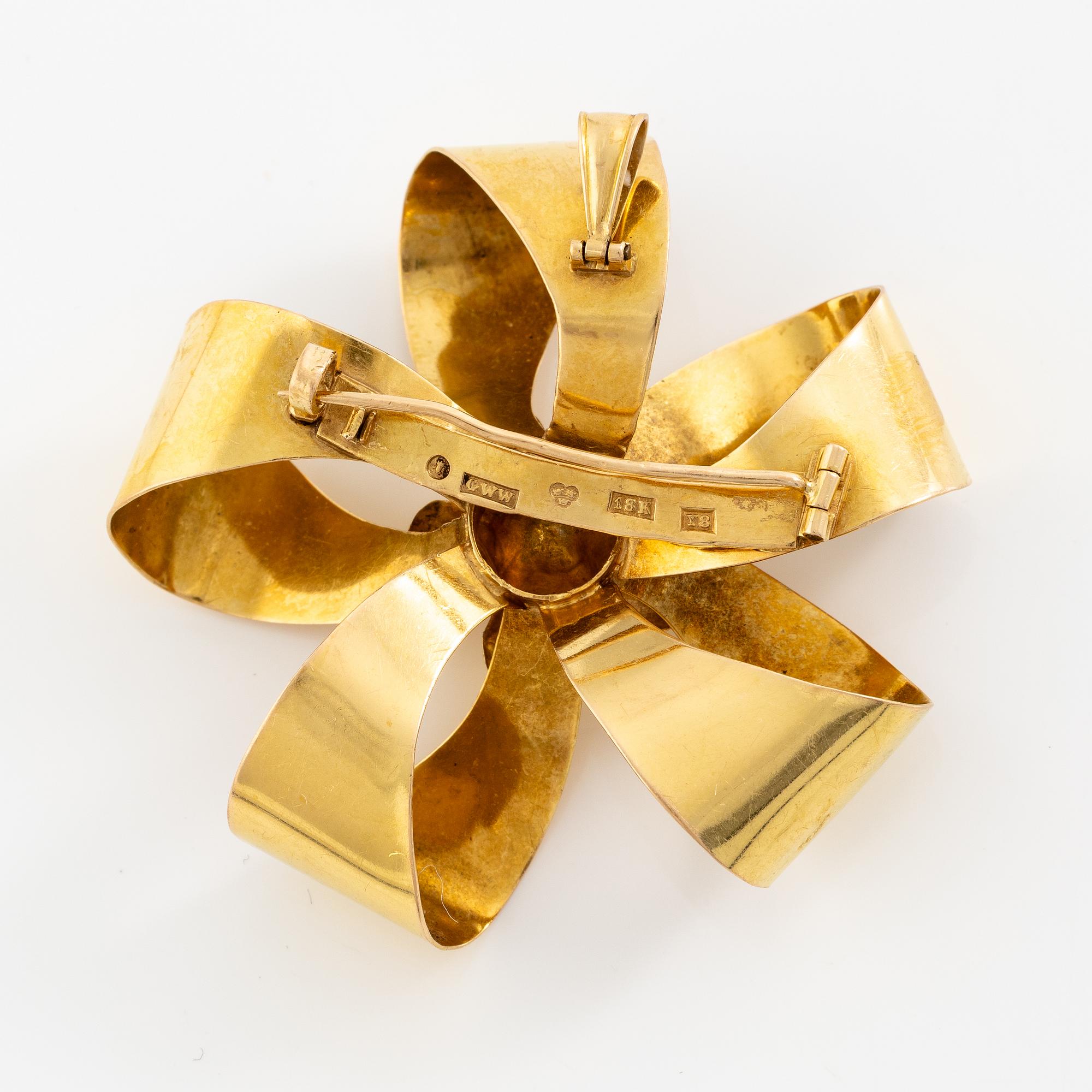 Brooch 18K gold with a white stone.