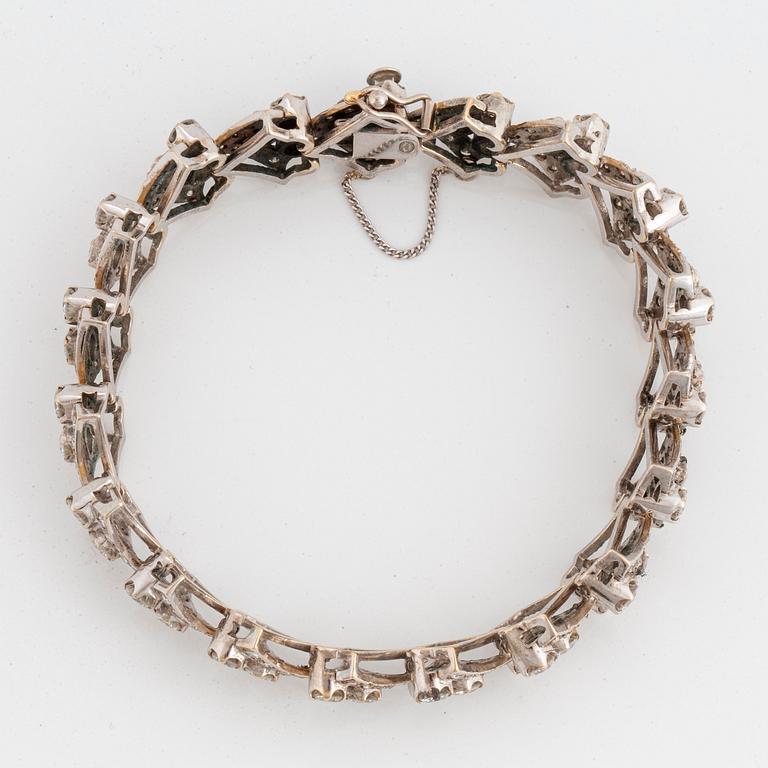 An 18K white gold bracelet set with round brilliant-cut diamonds.