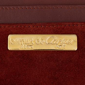 Cartier, a red suede clutch.