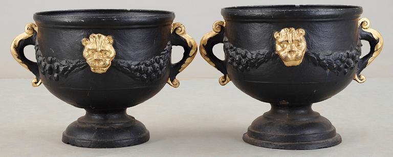 A pair of Baroque style 19th century iron cast garden urns.